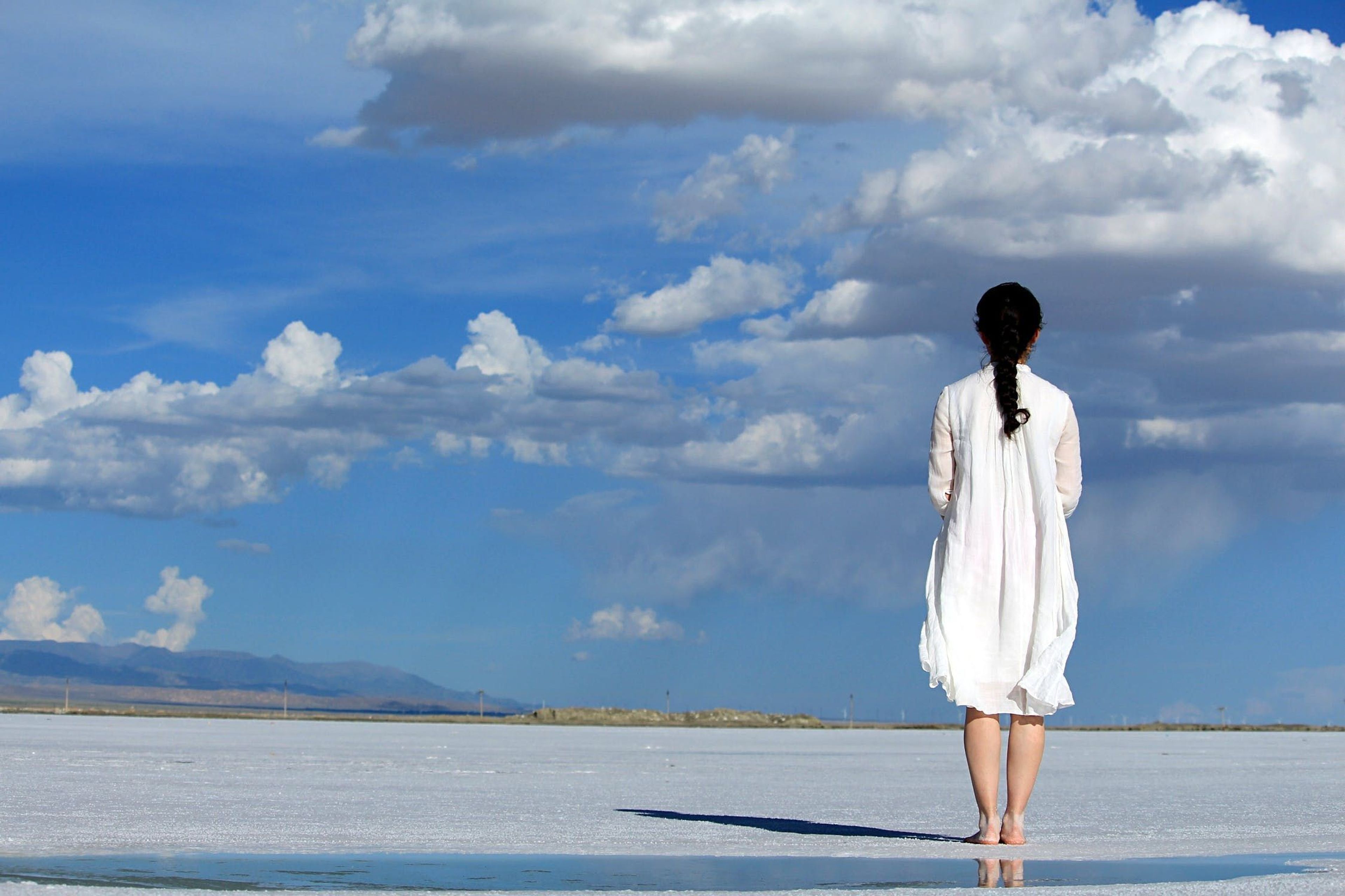 Woman standing on beach looking into the distance 