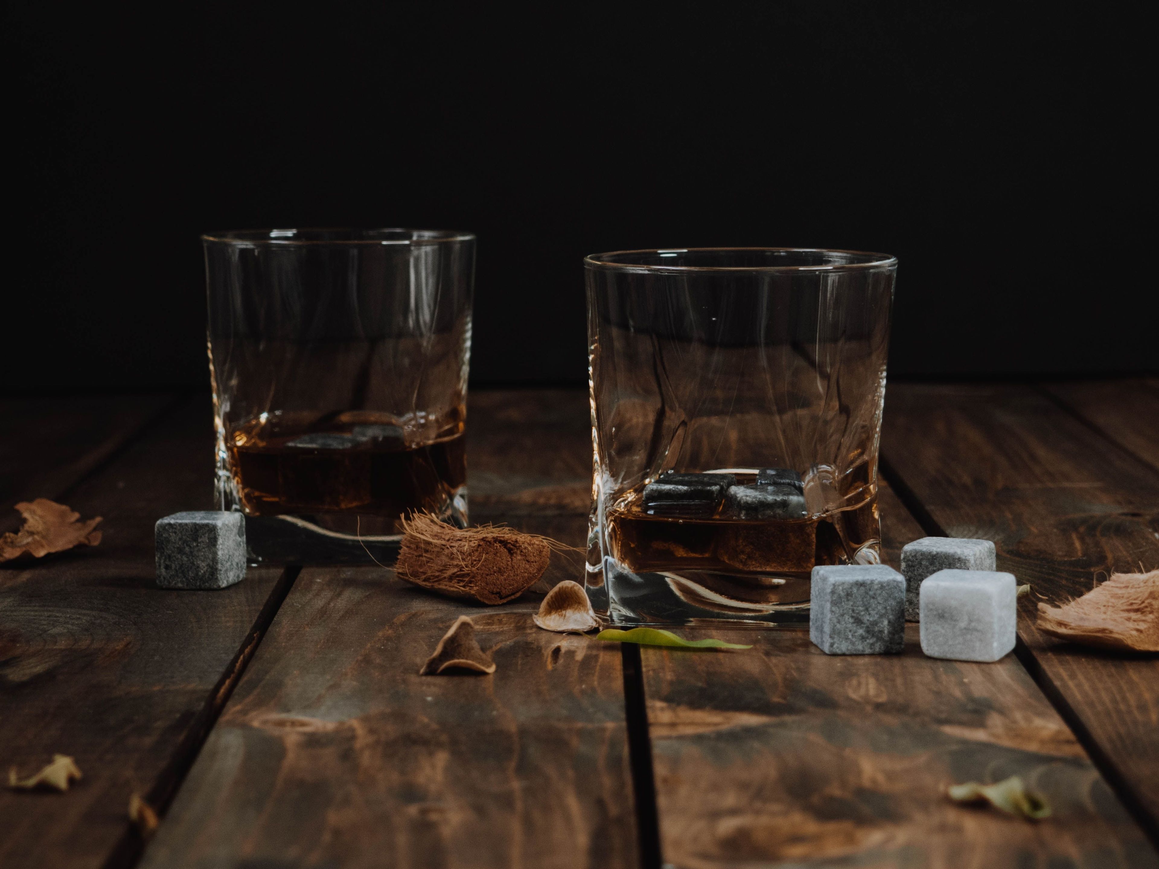 Two glasses of whiskey on wooden table 