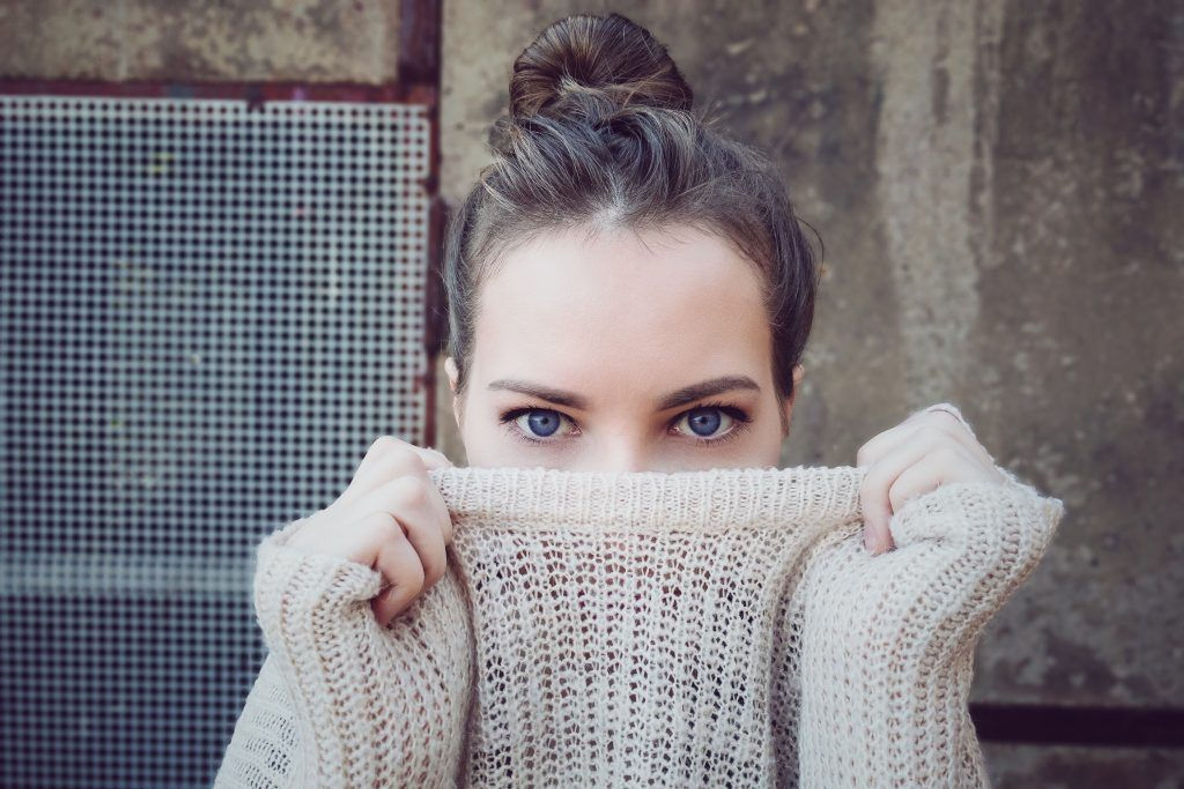 Woman pulling her sweater over her face 