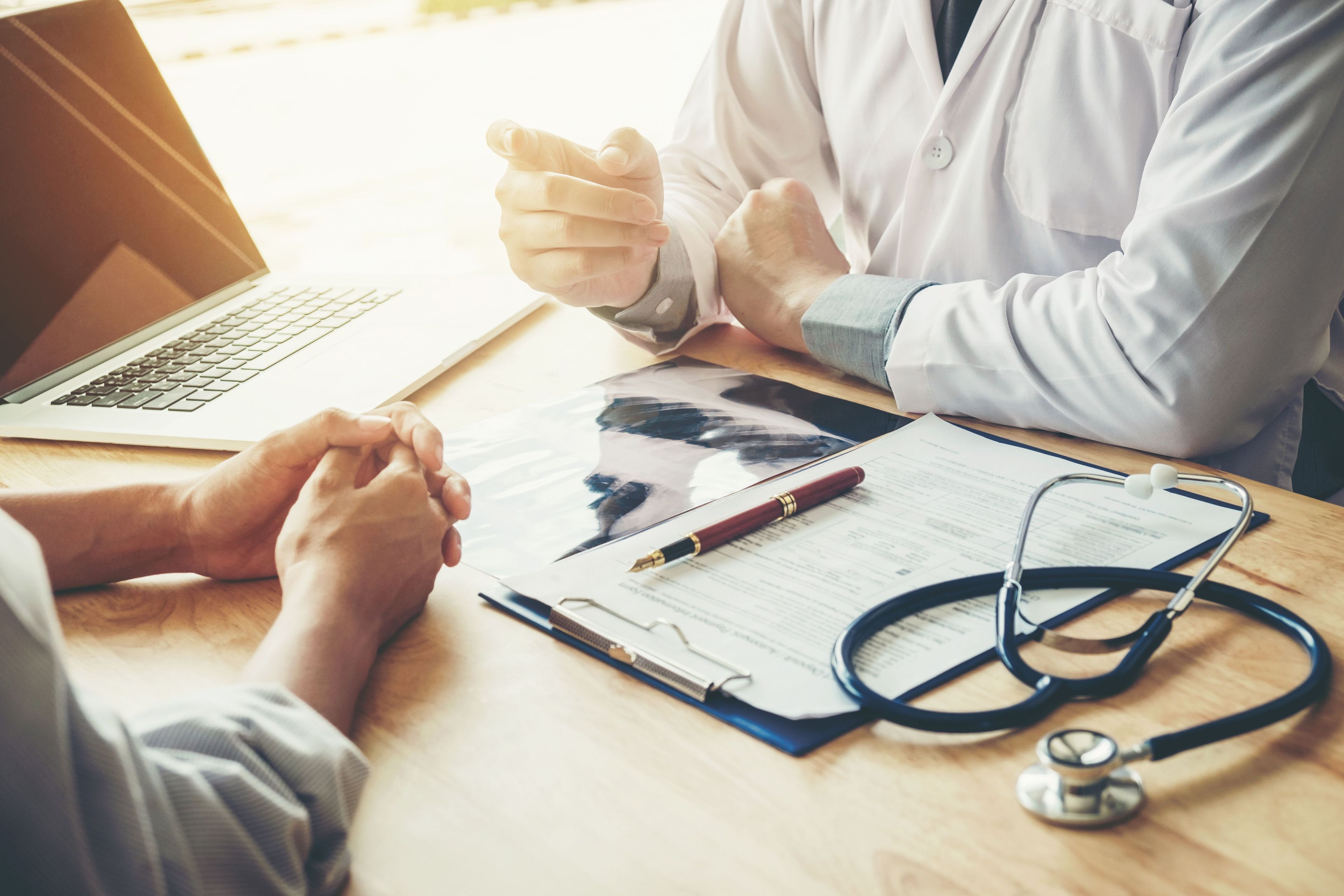 Doctor speaking to patient with their chart on the table