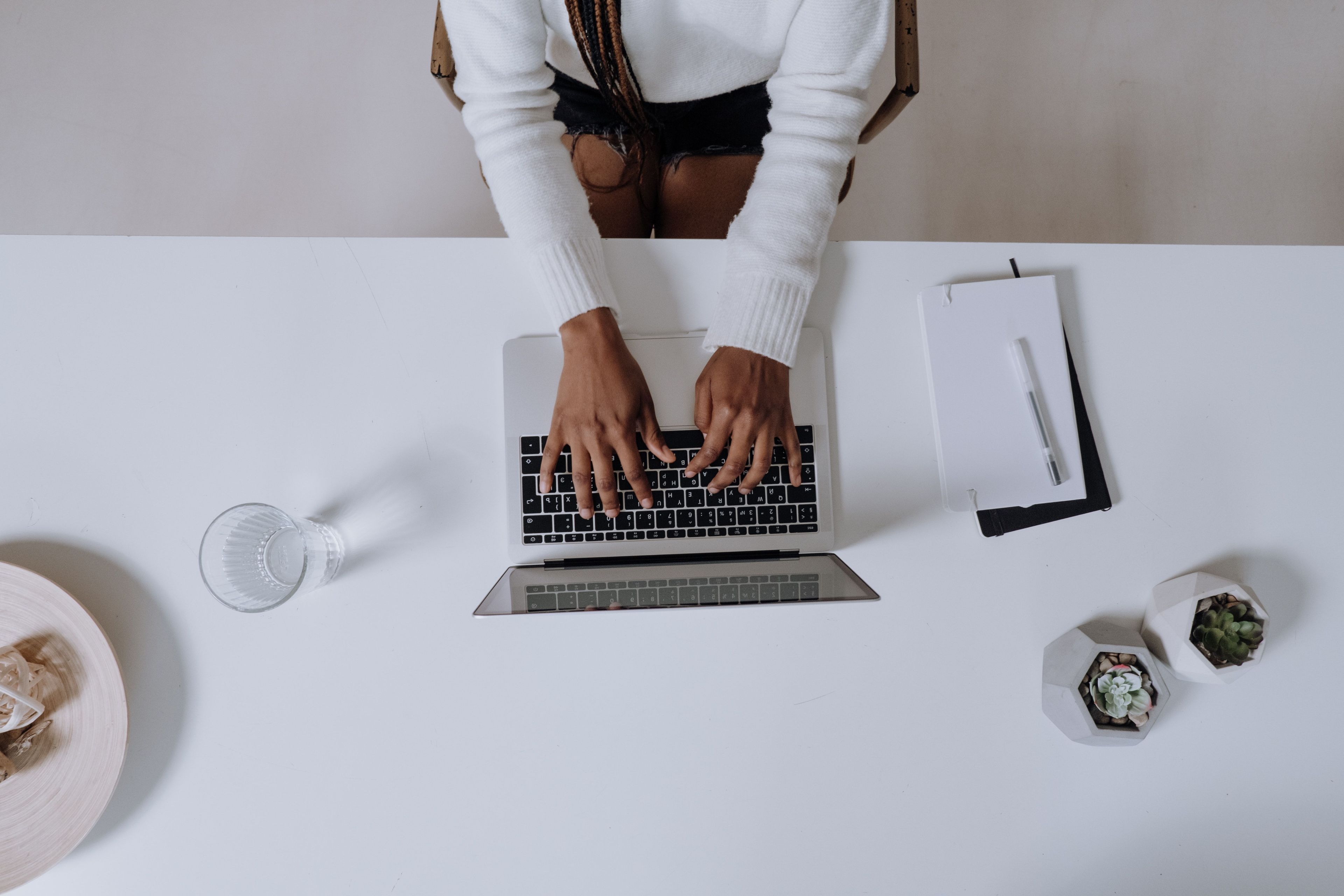Hands typing on laptop