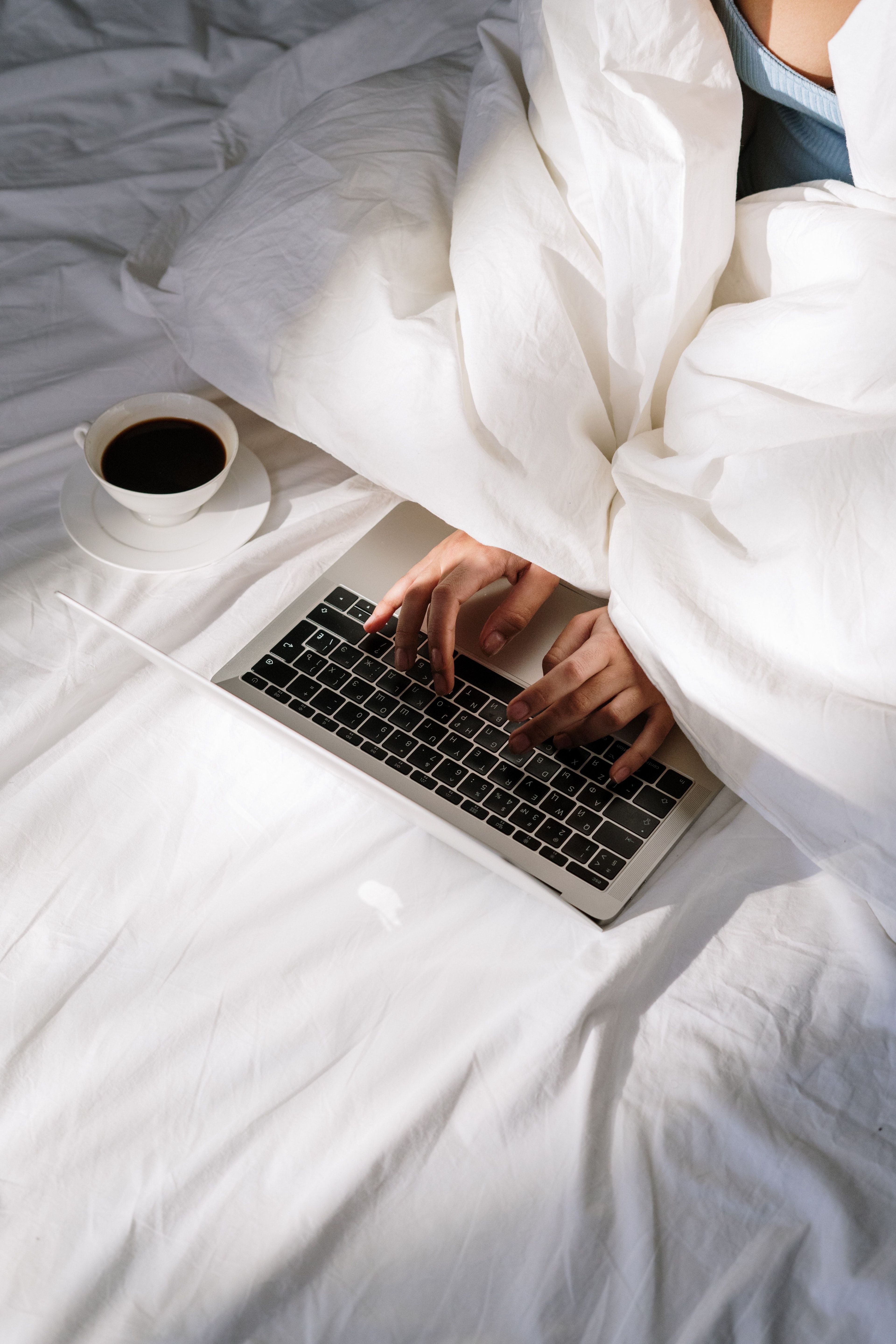 Woman working on laptop in bed 