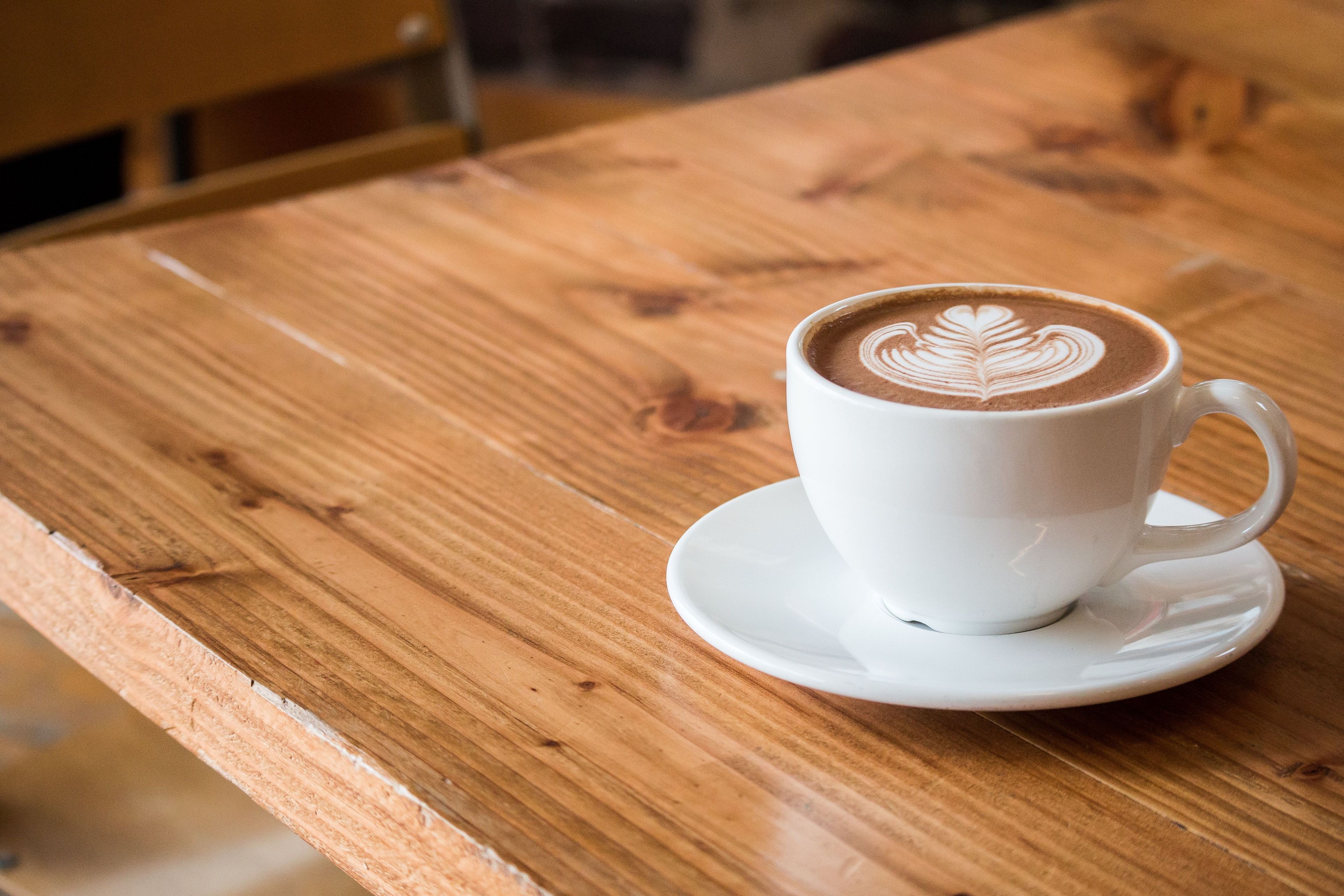 Latte in white mug on a wooden table 